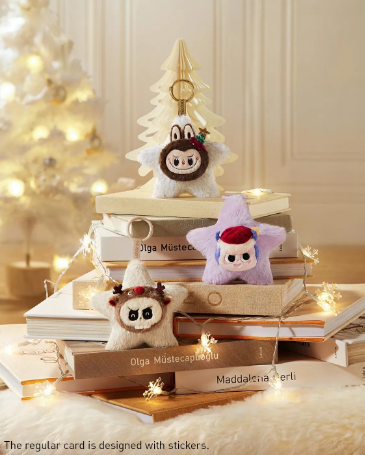 POP MART blind box collectibles plush keychains displayed on stacked books with festive holiday background